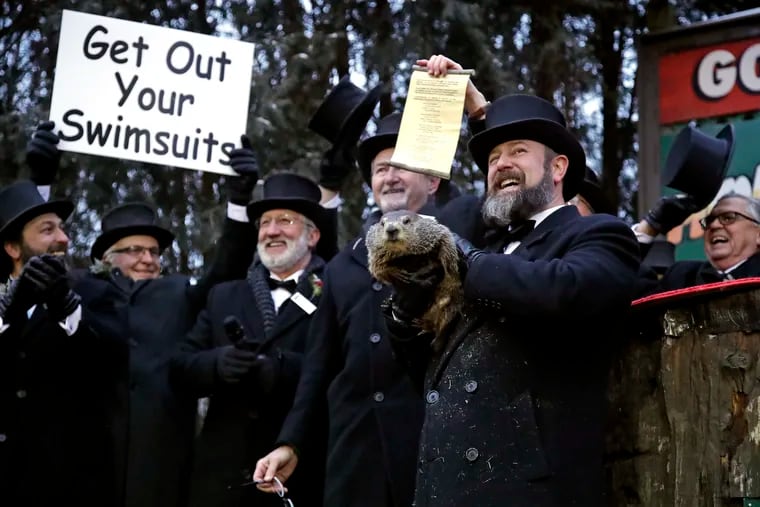 Groundhog Club co-handler Al Dereume, second from right, holds Punxsutawney Phil, the weather prognosticating groundhog, during the 133rd celebration of Groundhog Day on Gobbler's Knob in Punxsutawney, Pa. Saturday, Feb. 2, 2019. Phil's handlers said that the groundhog has forecast an early spring.