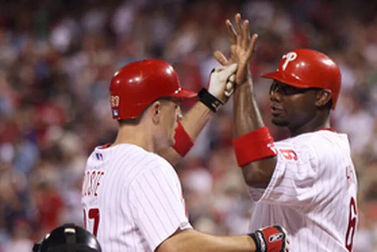 Chris Coste (four RBI) is greeted by Ryan Howard after three-run homer in sixth inning.