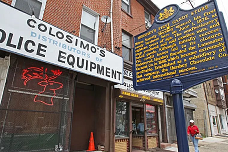 A new historical marker honoring Milton Hershey's first candy shop on Spring Garden Street stands in front of Colosimo's Police Equipment shop. ( Michael Bryant / Staff Photographer )