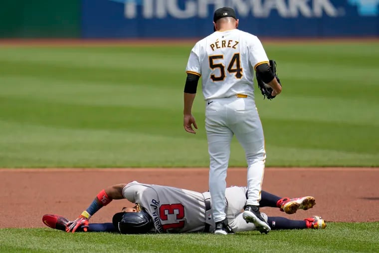 Pirates starting pitcher Martín Pérez checks on the Braves' Ronald Acuña Jr. who injured himself running the bases on Sunday. Acuña Jr. suffered a torn ACL in his left knee and is out for the season.