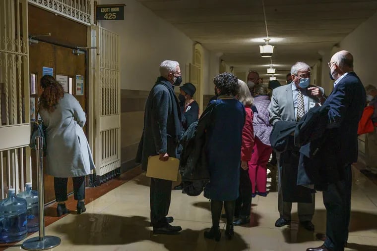 People wait outside in the hall prior to the start of a court hearing to decide if the city can legally transfer the priceless collection of the Philadelphia History Museum to Drexel, Monday, February 28, 2022.