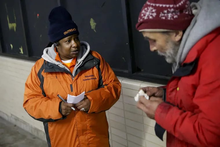 Project HOME outreach worker Michelle Sheppard, left, talks to a homeless man inside Suburban Station in Center City on Friday, Jan. 5, 2018. Sheppard, who herself was homeless for many years, now works to persuade homeless Philadelphians to seek shelter.