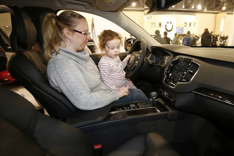 Victoria Opthof and daughter Dahlia, from Bethlehem, check out a new Volvo XC90 T6 Momentum at the 2017 Philadelphia Auto Show at the Pennsylvania Convention Center on Saturday.