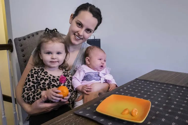 Morning snack time at Tabatha Griffith&#039;s home in Clarksboro, N.J. with her two daughters Bellamy, 2, holding an orange and Riley, 3 months.