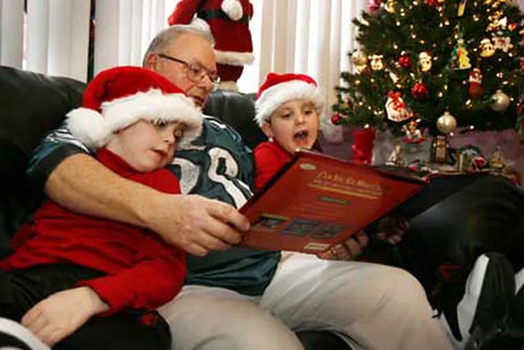 Joe Pizzo reads to his seven-year-old twin sons, Vinny (left) and Sonny in their South Philadelphia home. (Eric Mencher/Staff Photographer)