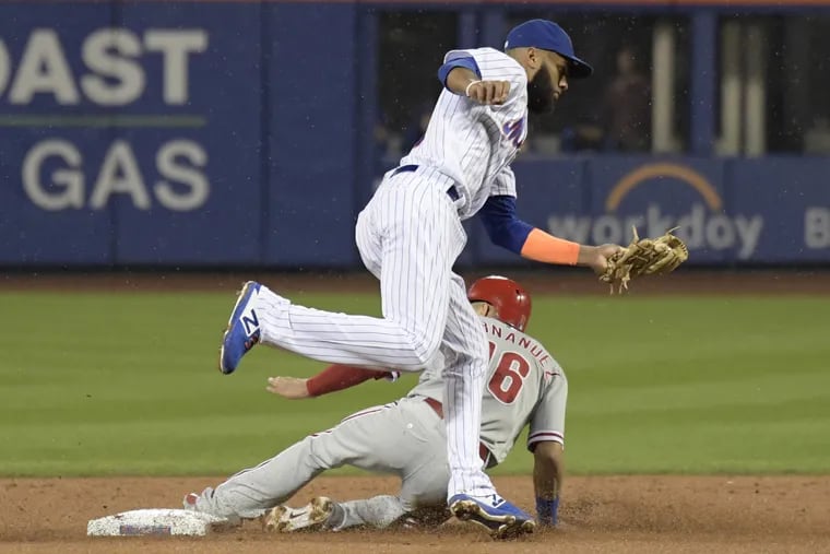 Phillies Cesar Hernandez (16) steals second base as New York Mets shortstop Amed Rosario takes the throw during the second inning of a baseball game Saturday, in New York.