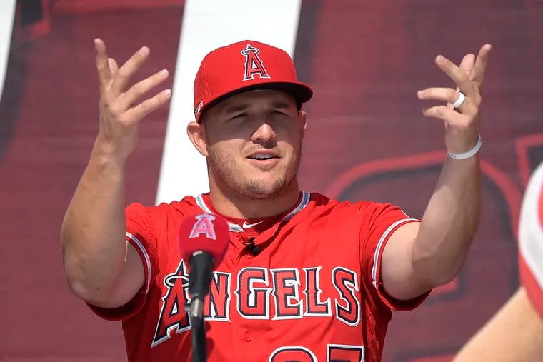 Mike Trout gestures to the crowd during a Sunday news conference about his contract extension.