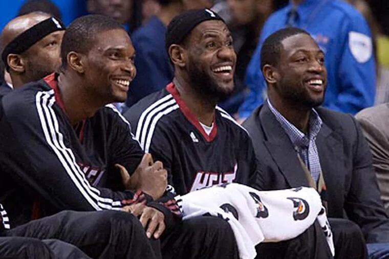 The trio of Chris Bosh, LeBron James and Dwyane Wade lead the Heat against the Sixers. (Darren Calabrese/AP Photo)