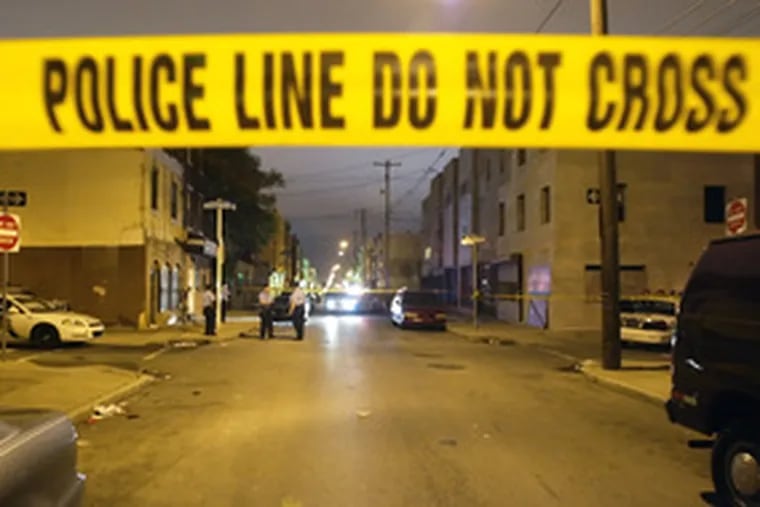 Police investigate the crime scene yesterday in the 700 block of Hoffman Street in South Philadelphia.