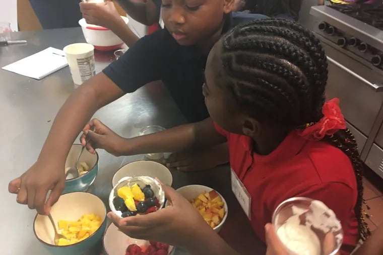 Nazhir Dungee and Jalynn Artis assemble their fruit and yogurt parfaits at Community Partnership School in North Philadelphia.
