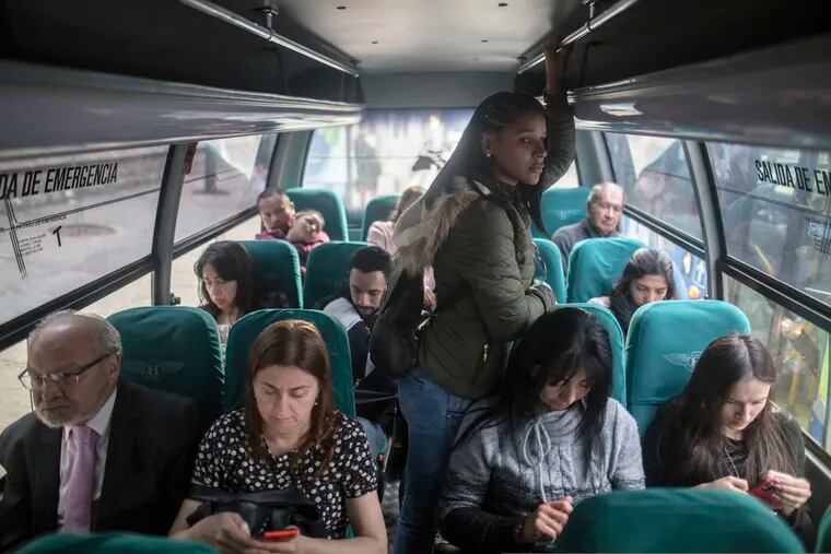 In this Dec. 11, 2018 photo, Venezuelan migrant Emili Espinoza commutes back home after a day's work at a health food restaurant in Bogota, Colombia. Like thousands of other Venezuelans migrating in the largest exodus in Latin America's modern history, Espinoza made an agonizing choice: To leave without her three children. (AP Photo/Ivan Valencia)
