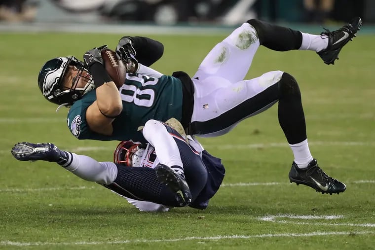 Eagles tight end Zach Ertz catches a pass in the fourth quarter as he lands on New England defensive back Devin McCourty.