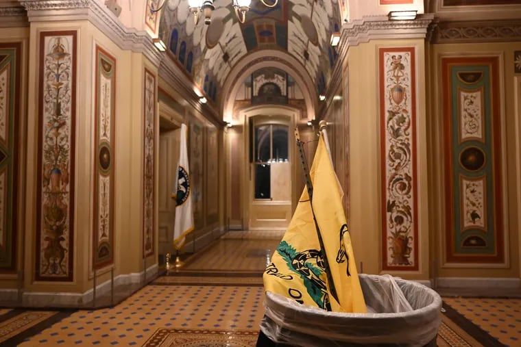 A “Don’t Tread On Me” flag is seen in a trash can during a clean up at the U.S. Capitol after a mob stormed the building Jan. 6. (Katherine Frey/The Washington Post)