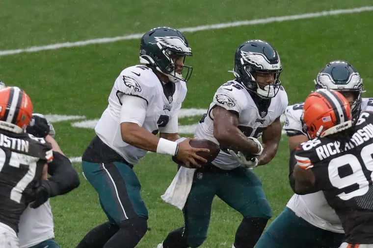 Eagles quarterback Jalen Hurts pulls the football back from running back Boston Scott during the second quarter against the Cleveland Browns.