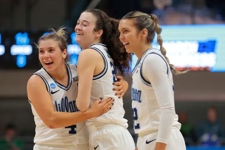 Maddy Siegrist (center) of Villanova celebrates with Kaitlyn Orihel (left) and Bella Runyan after making a bucket while getting fouled during the first half. The three-point play put Siegrist over 1,000 points on the season.