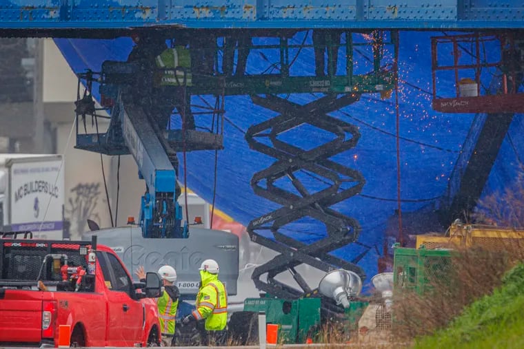 Work crews attend to damaged railroad bridge over I-95 as seen from Luzerne near Richmond Street on Tuesday morning.