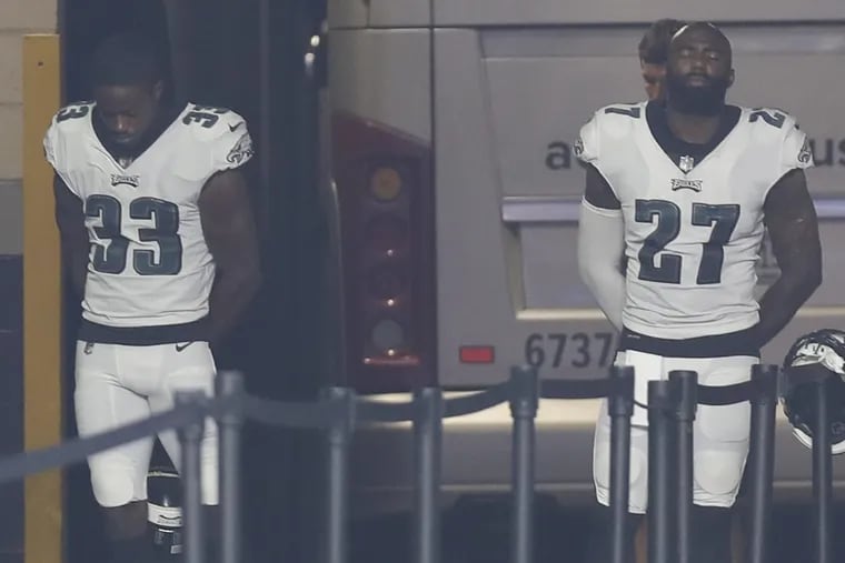 Eagles defensive backs Malcolm Jenkins and De'Vante Bausby stands in the Eagles tunnel during the national anthem before their preseason game against the Patriots on Thursday.