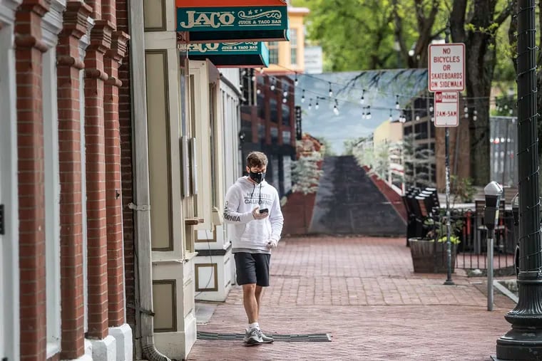 A man wearing a face mask walks along Gay Street in West Chester on May 11.