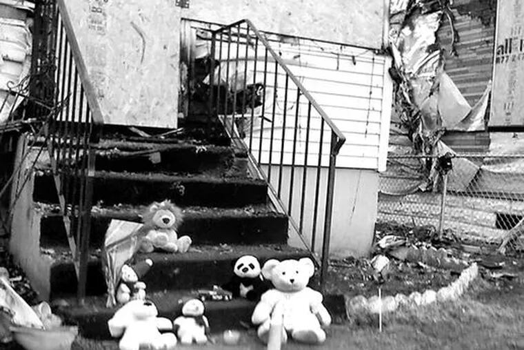 Passersby left toy tributes on the steps of the burned-out residence. A sister, 4, was among the survivors of the Thursday blaze.