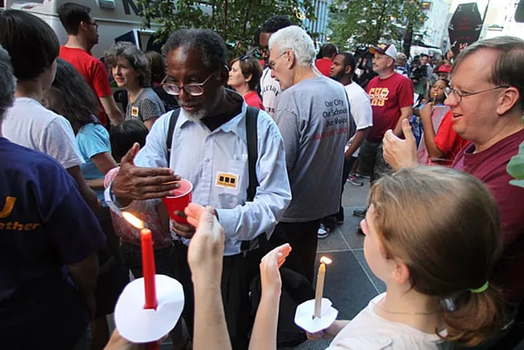 Members of the Philadelphia Teachers Union and Philadelphia Coalition Advocating for Public Schools light their candles during a vigil protesting education cuts in front of Gov. Tom Corbett's Center City Philadelphia office on South Broad Street on Sunday, September 8, 2013.  (Yong Kim / Staff Photographer)