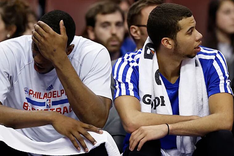 Thaddeus Young and Michael Carter-Williams sit on the bench before losing to the Bobcats. (Yong Kim/Staff Photographer)