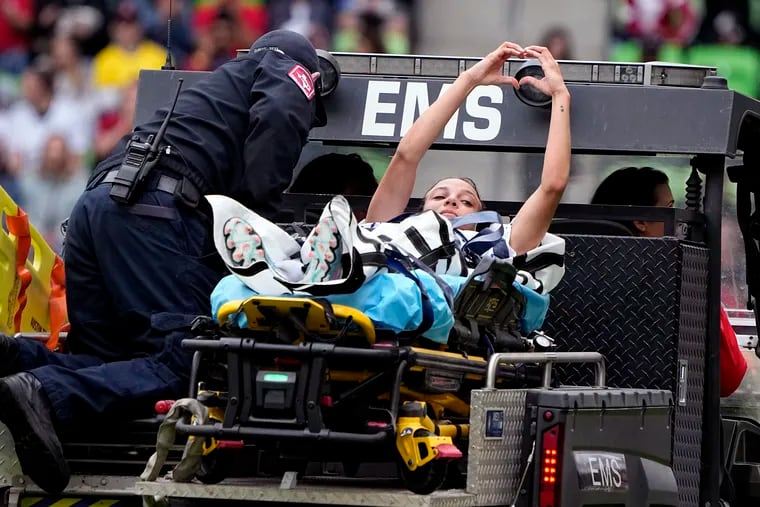 Mallory Swanson made a heart gesture to fans as she was carted off the field after suffering a torn patella tendon in her left knee in Saturday's game against the Republic of Ireland.