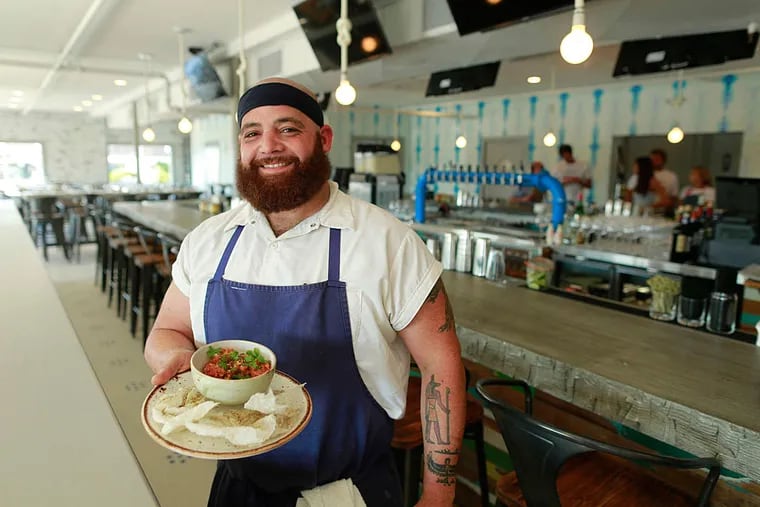 Executive chef Happy Hatab holds a conch roll at Daymark in Barnegat Light, N.J.
