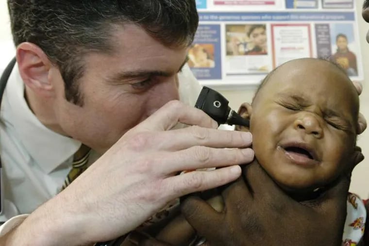 Pediatrician Daniel Taylor examines a young patient.