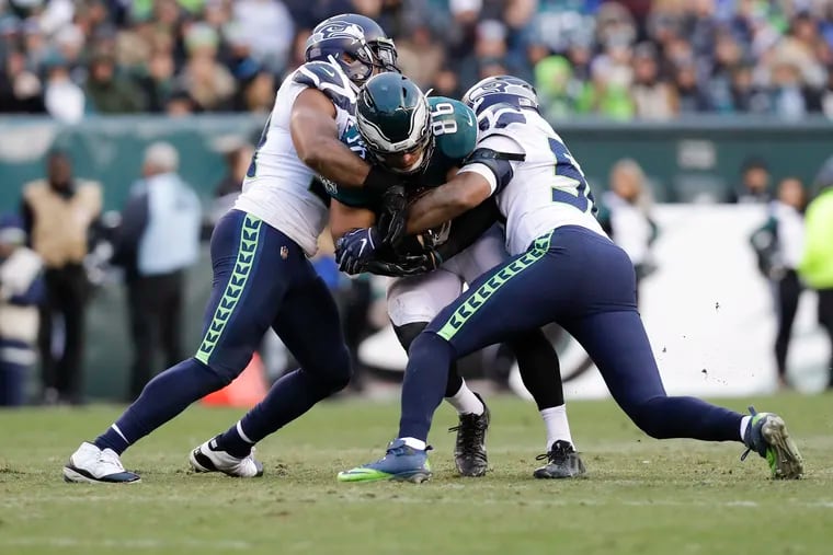 Seahawks linebackers Bobby Wagner (left) and K.J. Wright (right) take down Eagles tight end Zach Ertz in November.