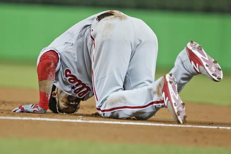 Phillies outfielder Pedro Florimon grimaces after injuring himself heading to first base during the second inning of a baseball game against the Miami Marlins on Saturday. He left and did not return.