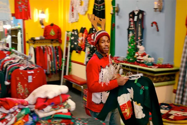 Ugly Christmas sweater parties have taken off, so much so that an entire pop-up shop at 38 N. 3rd St. has been dedicated to them, where employee David Morton (cq) brings out fresh sweaters December 6, 2012. ( TOM GRALISH / Staff Photographer )