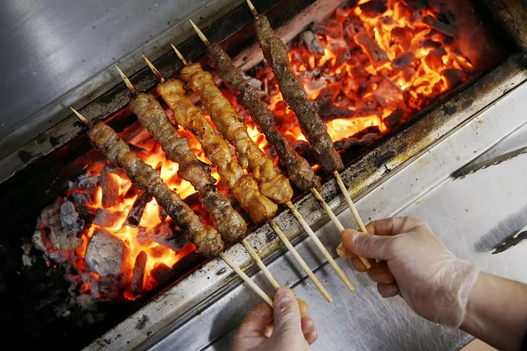 Chef and owner Dongtian Xia turns meat skewers over the charcoal grill at TT Skewer in Philadelphia's Chinatown on Friday, April 2, 2021.