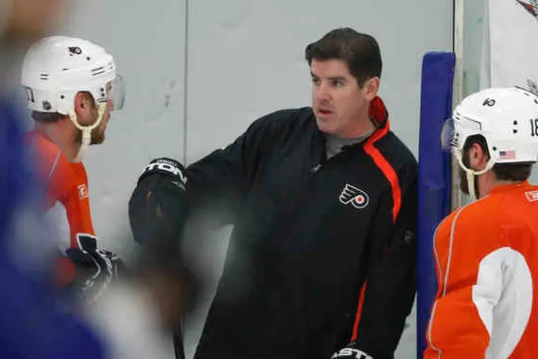 Peter Laviolette talks wtih Jeff Carter (left) and Mike Richards during practice yesterday.