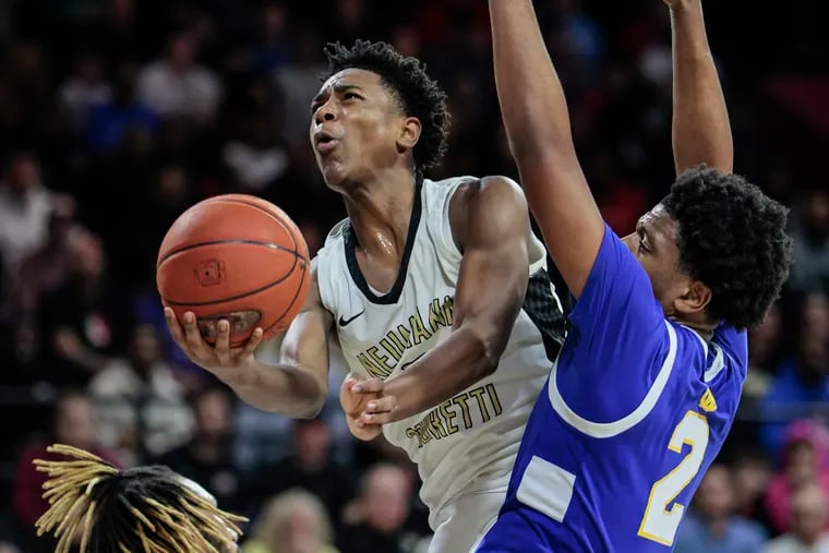 Neumann Goretti’s Robert Wright III goes up between West Catholic’s Marcus Branker Jr., left, and Zion Stanford, right.