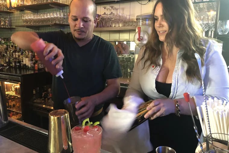 Bartender Anwar Morgan and Michelle Curtis, an account specialist with Campari America, mix a drink at Bar Amis.