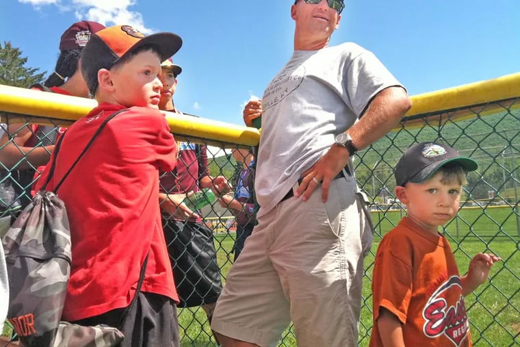 Kevin Lawrence and his son, Connor (left), 8, chat with Mo’ne Davis along the fence after the Taney Dragons held batting practice yesterday in South Williamsport.