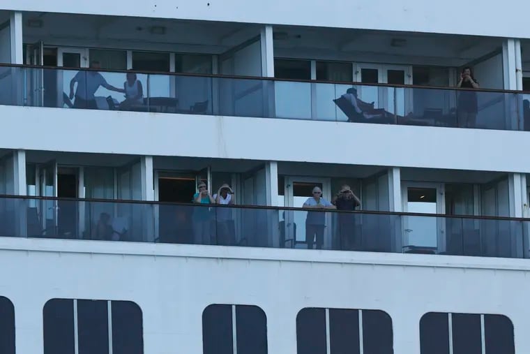 Passengers look out from the Zaandam cruise ship.