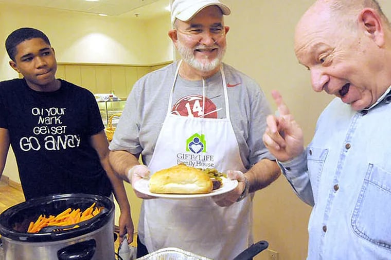 At the Gift of Life Family House, Jimmy Powell (center) cooks for other guests, including Gary Prager (right) and Leo Draper.