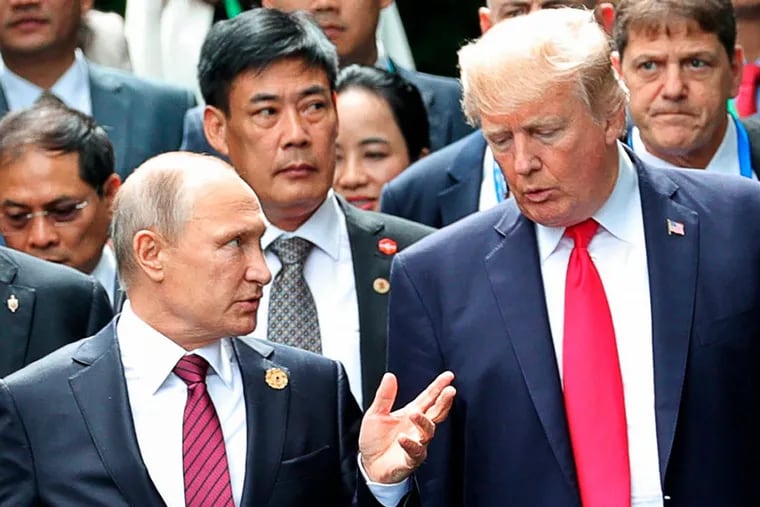 President Trump, right, and Russia President Vladimir Putin talk during the family photo session at the APEC Summit in Danang in November 2017.