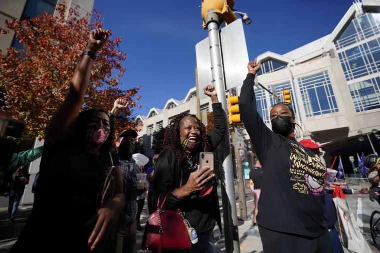 Voters react to the news that Joe Biden wins Pennsylvania, and with it, the presidency, and Kamala Harris elected the first Black, Asian American, female vice president on Nov. 7 outside of the Pennsylvania Convention Center in Philadelphia.