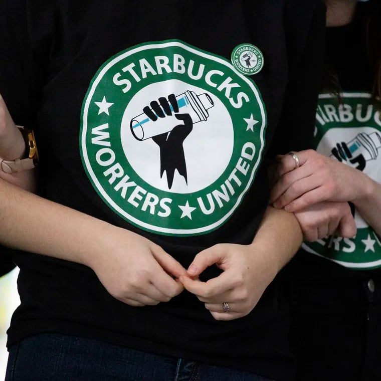 Starbucks employees and supporters link arms during a union election watch party in 2021 in Buffalo, N.Y.