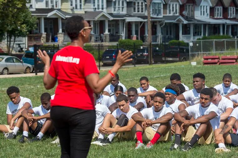Maxayn Gooden speaks to players before a "Practice 4 Peace" joint football practice between Boys Latin and Frankford High on Wednesday. Her son, Boys' Latin defensive back Jahsun Patton was shot and killed last season. Frankford also lost a player last year as a result of violence among teens.