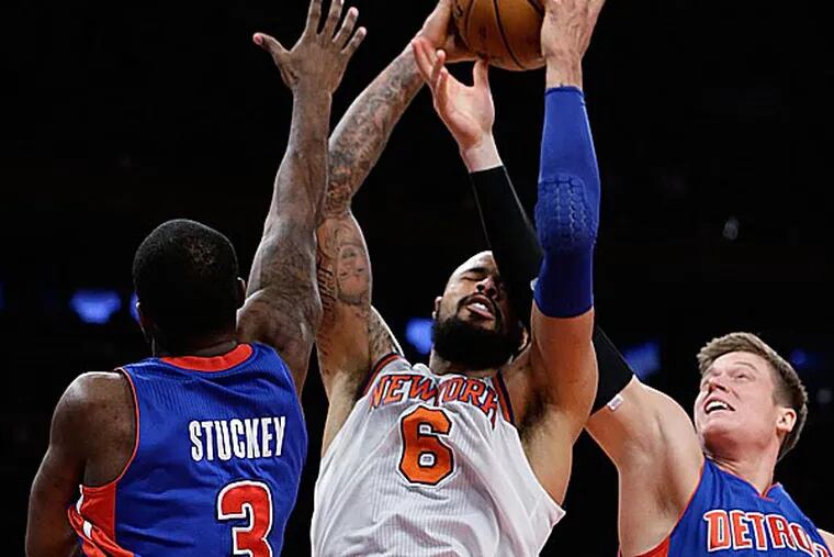 New York Knicks center Tyson Chandler grabs a rebound as Detroit Pistons guard Rodney Stuckey and forward Jonas Jerebko try to get the ball back beneath the Pistons' basket. (Kathy Willens/AP)