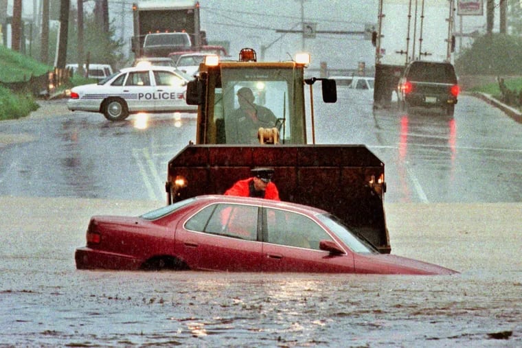 An Upper Merion Police offficer talks to the driver of this car who became trapped by Floyd's floodwater at an underpass on South Gulph Road near Route 202 on Sept. 16, 1999.