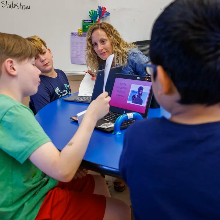 Quakertown Elementary School third-grade teacher Melissa Riedi works with Owen Maguire (left), 9, pictured in green, on a Living Wax Museum lesson with a RIASEC component. Also shown are Wyatt Roeder, 9, and Hector Herrera (right), 9.