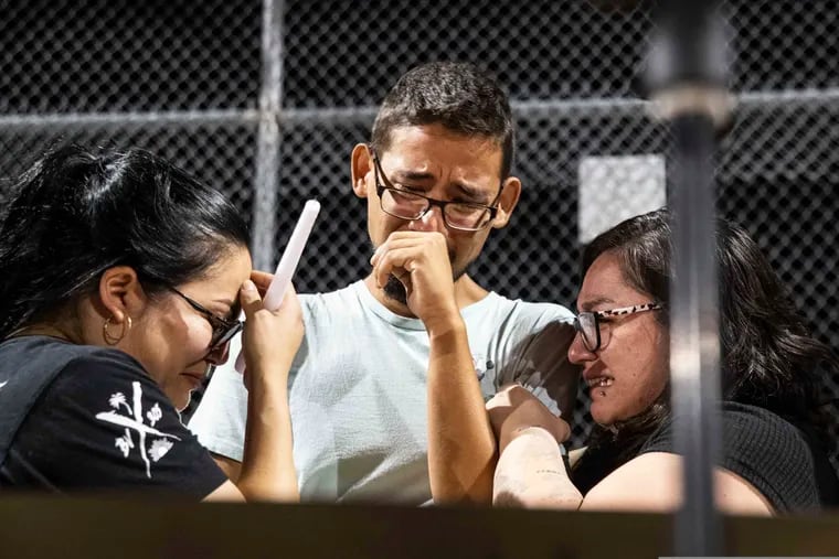 Three Walmart workers, Melisa Gonzalez, Jesus Romero and Raven Ramos, who helped people to escape during the mass shooting on Saturday, get emotional during during a vigil at Ponder Park in honor of the shooting  victims in El Paso, Texas on Sunday.