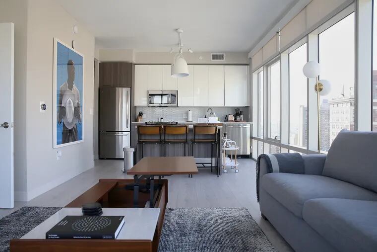 The living room and kitchen in a two-bedroom suite, offered as a short-term rental by Lyric, are pictured in the 1213 Walnut apartment building in Center City.