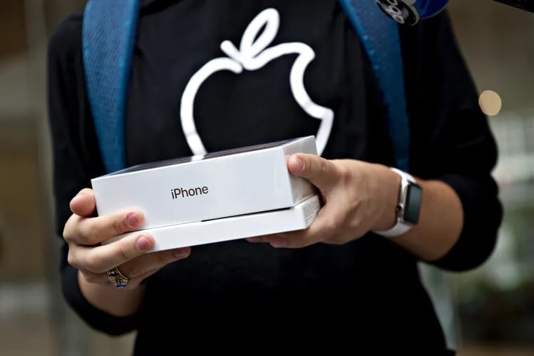 A customer holds an Apple iPhone XS Max box at a store in Chicago in 2018.
