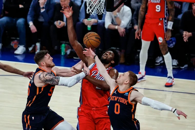 Sixers Joel Embiid loses the ball between  Knicks Isaiah Hartenstein left and Donte DiVincenzo right during the third quarter of Game 2 of the NBA Eastern Conference playoffs at Madison Square Garden in New York on Monday, April 22, 2024.