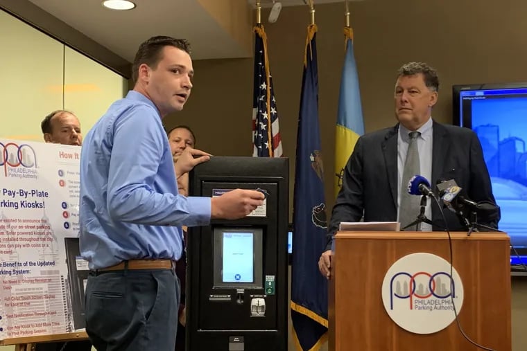 The Philadelphia Parking Authority's Bill Wasser demonstrates how to use the new parking kiosks as the PPA's chief executive, Scott Petri, watches.